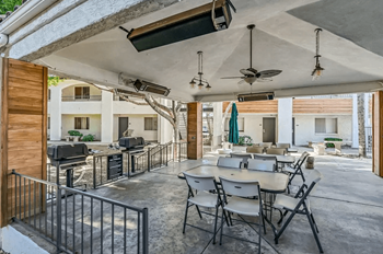 A patio with a table and chairs is covered by a roof at Tides on East Cactus Apartments, Arizona